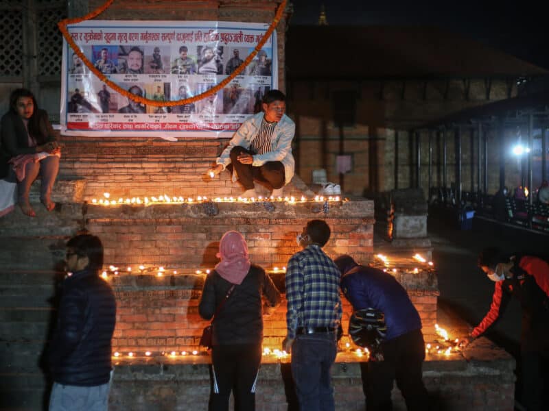 Photo of families lighting up lamps during a vigil for a deceased Nepali citizen in Russia.