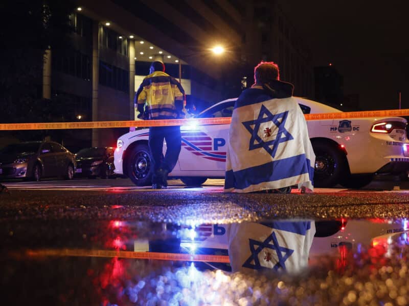 A police officer cordons off the perimeter outside the Capital Jewish Museum in Washington, D.C., after two Israeli Embassy staff members were shot dead. Authorities have arrested a suspect, and the FBI is investigating the incident as a possible act of antisemitic terrorism.