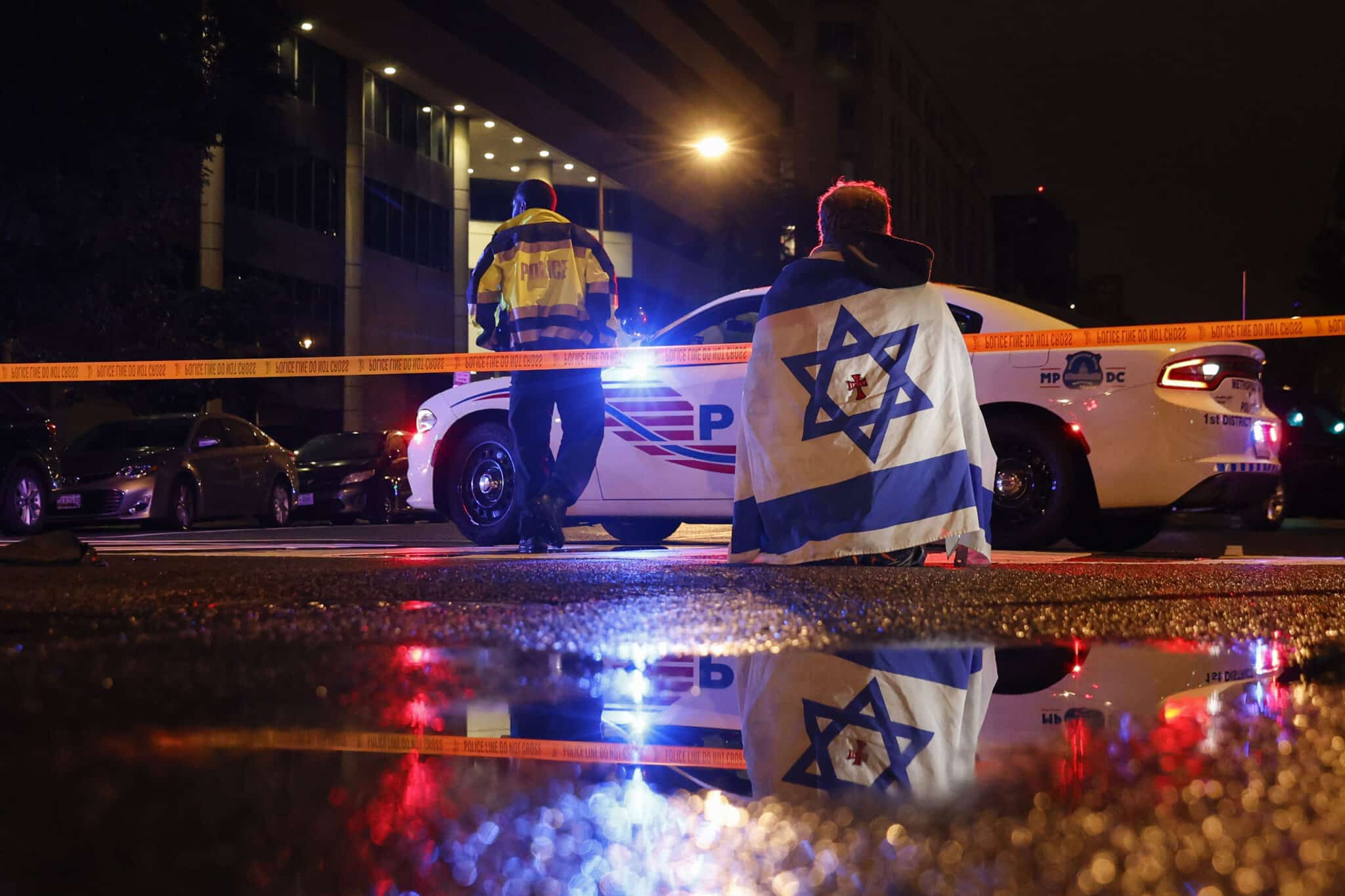 A police officer cordons off the perimeter outside the Capital Jewish Museum in Washington, D.C., after two Israeli Embassy staff members were shot dead. Authorities have arrested a suspect, and the FBI is investigating the incident as a possible act of antisemitic terrorism.