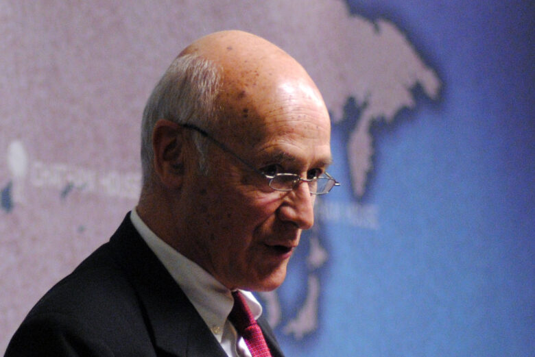 Profile photo of Joseph Nye standing in front of a map.
