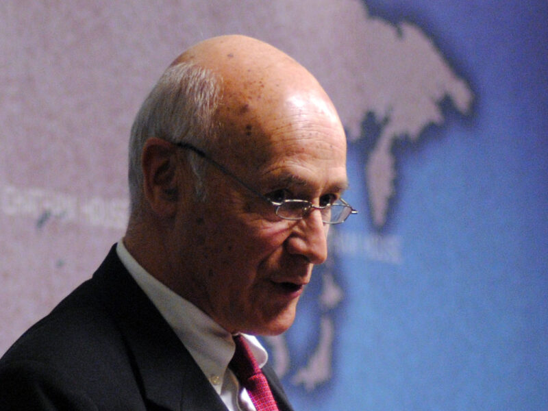 Profile photo of Joseph Nye standing in front of a map.