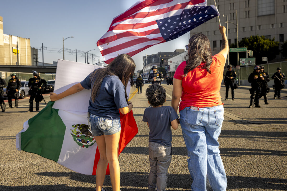 People with an upside-down American flag face off with police as protests continue following four days of clashes with police after immigration raids continue across the country on June 10, 2025, in Los Angeles, California, USA.