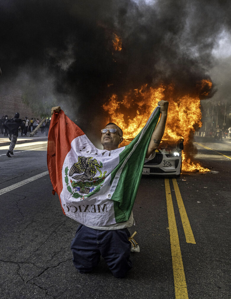 June 8, 2025, Los Angeles, California, USA: Anti-ICE (U.S. Immigration and Customs Enforcement) protester in Los Angeles in front of a Waymo car that was set on fire.