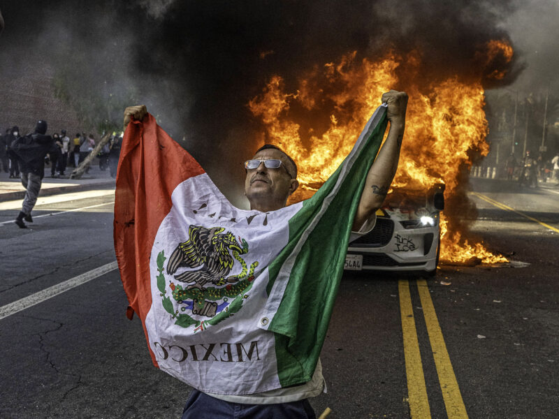 June 8, 2025, Los Angeles, California, USA: Anti-ICE (U.S. Immigration and Customs Enforcement) protester in Los Angeles in front of a Waymo car that was set on fire.