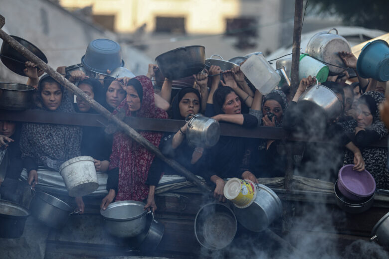 Photo of Palestinians waiting for meal distribution by charity organizations.