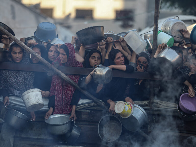 Photo of Palestinians waiting for meal distribution by charity organizations.