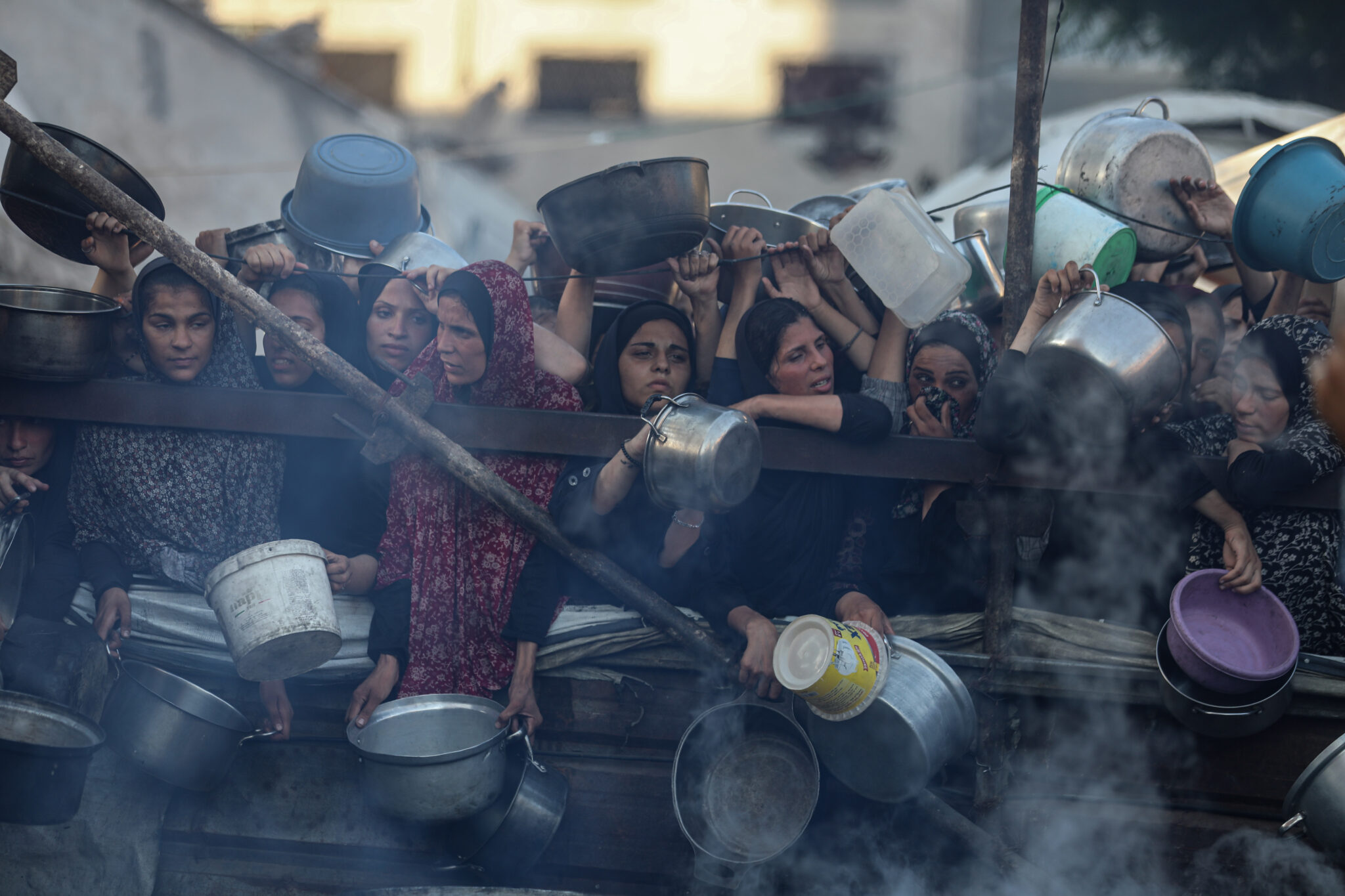 Photo of Palestinians waiting for meal distribution by charity organizations.