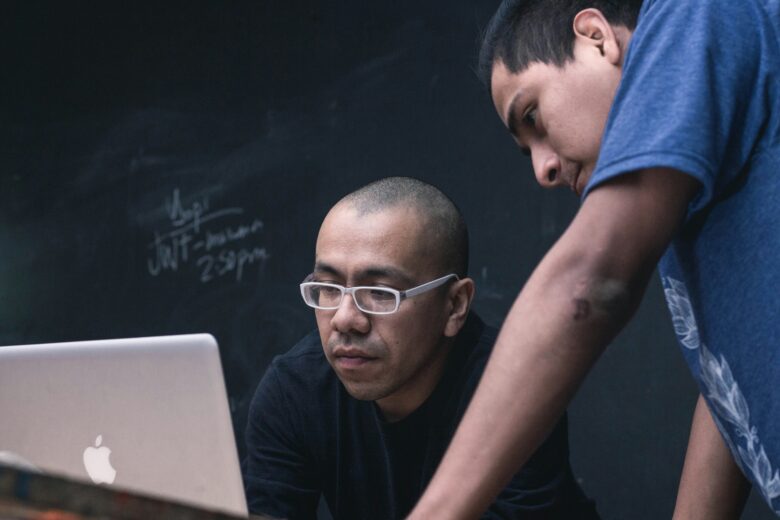 Photo of two people looking at a computer screen.