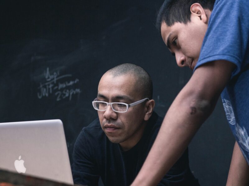 Photo of two people looking at a computer screen.