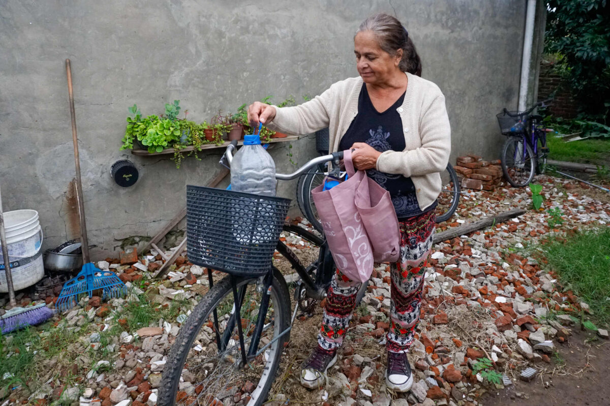 Beatriz Cruz, 62, loads a water jug on her bicycle in Nueve de Julio, Buenos Aires province.
