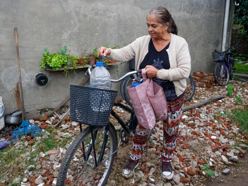 Beatriz Cruz, 62, loads a water jug on her bicycle in Nueve de Julio, Buenos Aires province.
