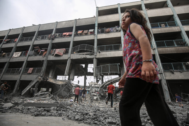 Palestinians inspect the destruction of Al-Falah School in the Zaytoun neighborhood after Israeli airstrikes reduced classrooms and shelter areas to rubble after missile strikes on Monday, leaving 74 people dead.