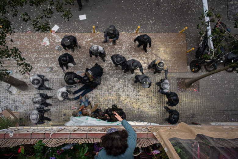 Overhead shot of the Mossos d'Esquadra filled with flour by the people who tried to stop the eviction of a family for non-payment of rent in the Poble-sec neighborhood, on December 14, 2022, in Barcelona (Catalonia).