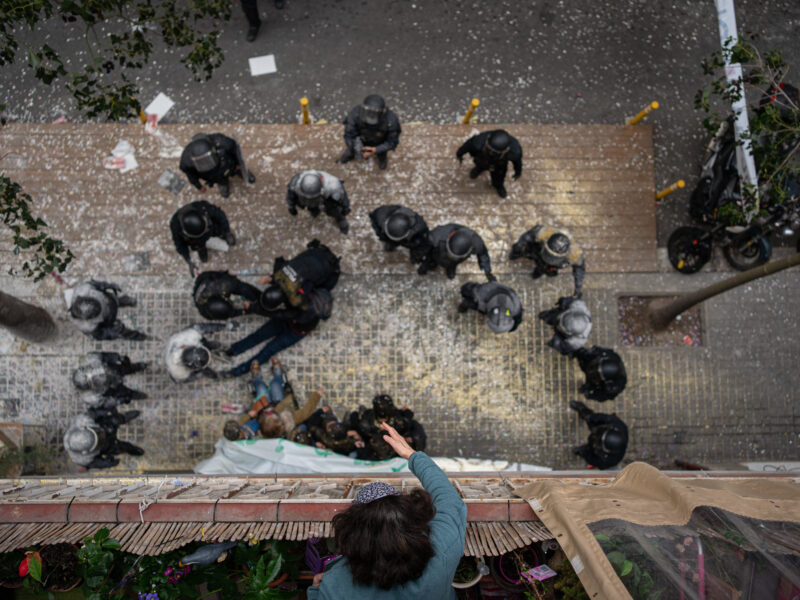 Overhead shot of the Mossos d'Esquadra filled with flour by the people who tried to stop the eviction of a family for non-payment of rent in the Poble-sec neighborhood, on December 14, 2022, in Barcelona (Catalonia).