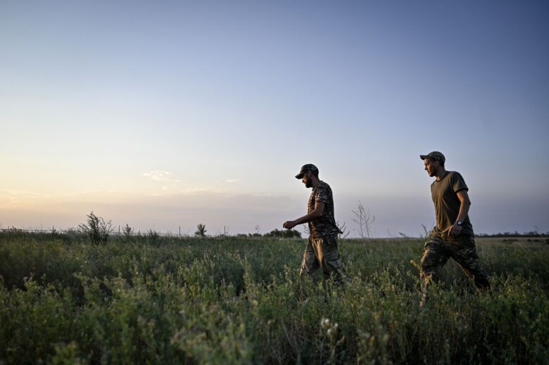 Servicemen walk through a field during a combat mission near Chasiv Yar, Bakhmut district, Donetsk region in eastern Ukraine on July 14, 2024.