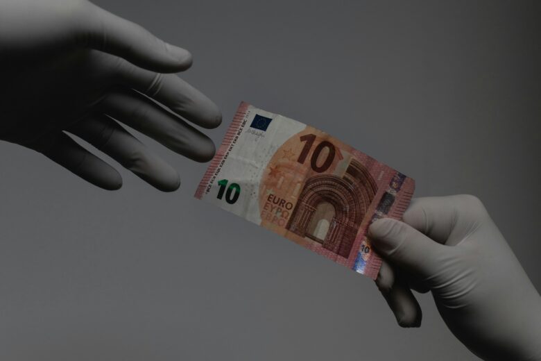 A 10 euro bill being passed.