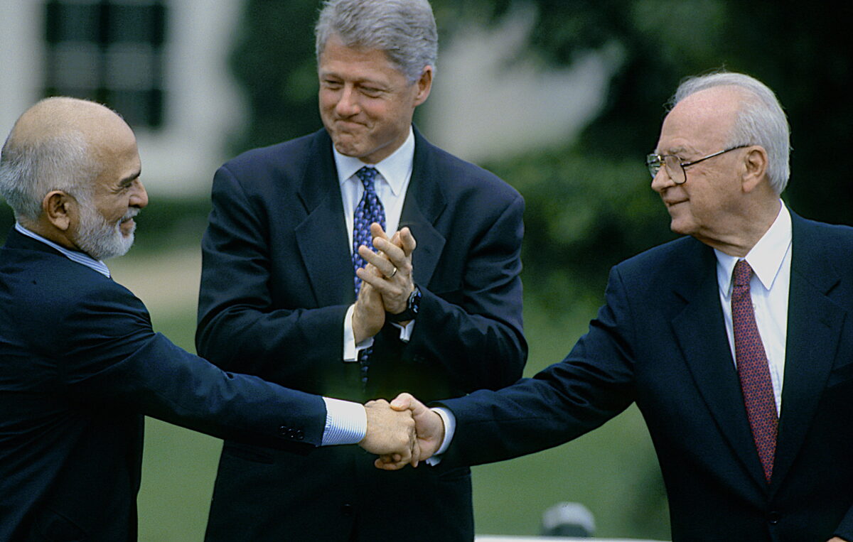 A handshake between Hussein I of Jordan and Yitzhak Rabin, accompanied by Bill Clinton, during the Israel-Jordan peace negotiations at the White house.