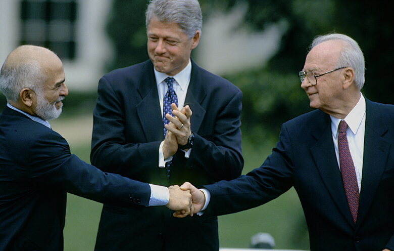 A handshake between Hussein I of Jordan and Yitzhak Rabin, accompanied by Bill Clinton, during the Israel-Jordan peace negotiations at the White house.