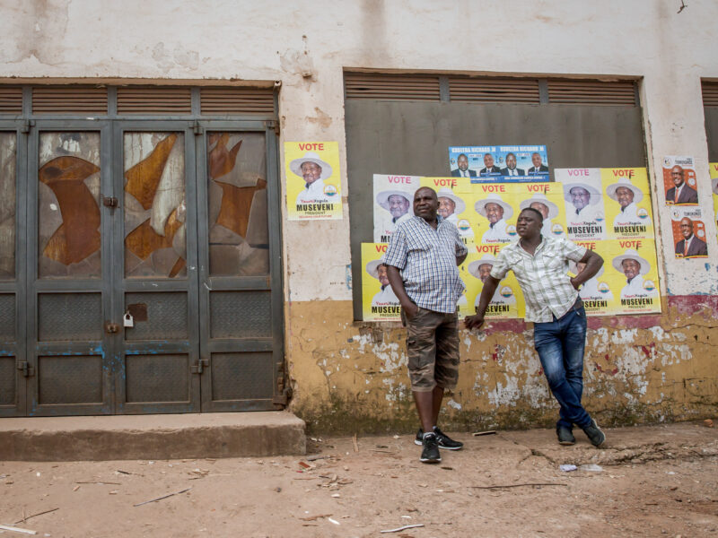 Kampala, Central Region, Uganda: Men stand in front of posters of Yoweri Museveni, Uganda's long-time president.