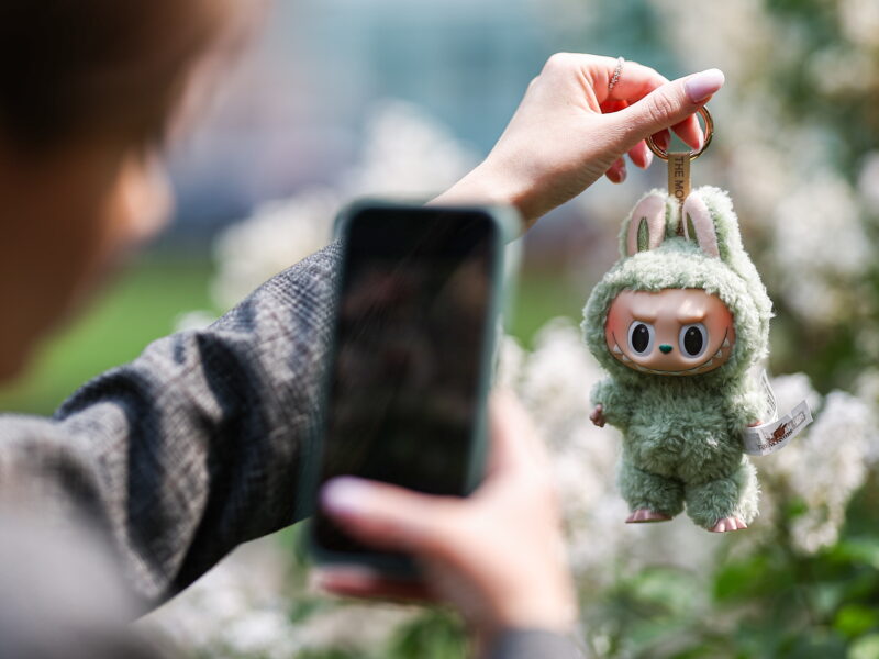 Moscow, Russia, June 2025: A proud owner photographs a Labubu keyring doll.