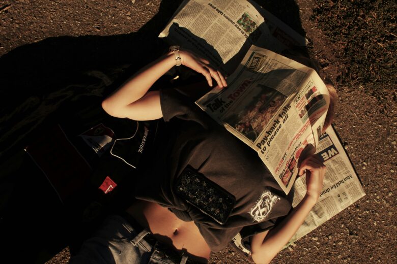 Woman covering her face with a newspaper