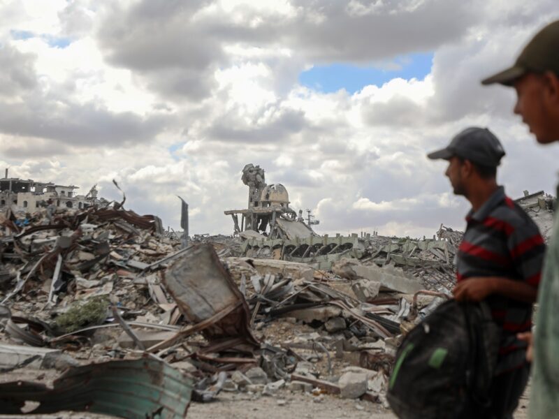 Palestinians walk past the rubble of destroyed buildings after returning to Khan Younis, in southern Gaza, on Oct. 12, 2025.