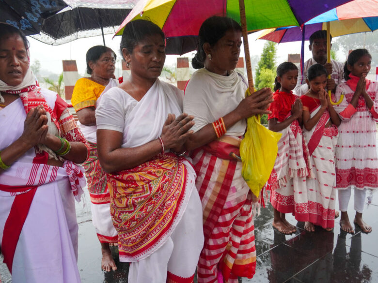 Followers of the Sarna faith perform prayer rituals at a place of worship every Thursday, wearing white and red as symbols of peace and resistance.