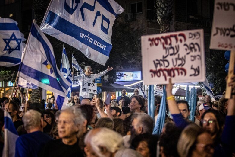 Protestors hold signs during the Rabin memorial rally on November 1, 2025, Tel Aviv, Israel.