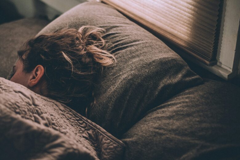 Woman sleeping under blankets.
